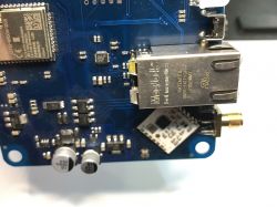 A section of a blue PCB with electronic components, MagJack Ethernet connector, and ESP32 module.