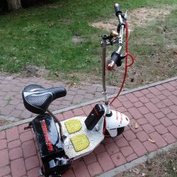 Elektryczna hulajnoga z trzema kołami i siedzeniem.