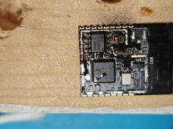 Close-up of a PCB section with ICs and “WIFI” marking, partly covered with a white residue