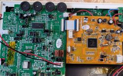 Zbliżenie na dwie różne płytki drukowane, jedna zielona, druga pomarańczowa, pokazujące układy elektroniczne.