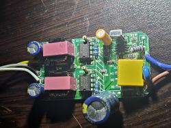 View of a circuit board with electronic components like capacitors and BP2958 drivers on a wooden background.