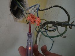 Próbnik napięcia świeci się po dotknięciu niepodłączonego kabla w puszce elektrycznej