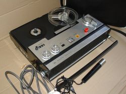 Magnetofon szpulowy Sharp z mikrofonem i przewodami na tle tektury