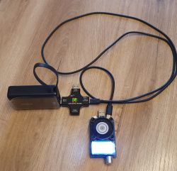 Powerbank Baseus podłączony do cyfrowego testera USB i obciążenia elektronicznego na drewnianej podłodze