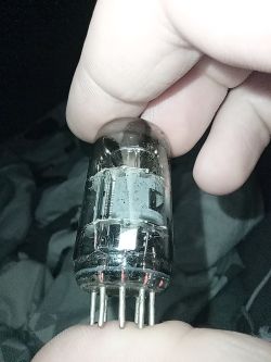 Lampa elektronowa trzymana w palcach, widoczne siedem nóżek u podstawy
