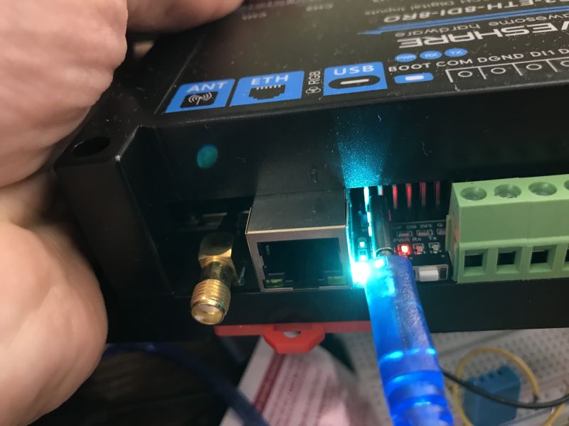 Close-up of ESP32-S3-ETH-8DI-8RO ports with active blue LED and USB cable