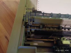 Wnętrze drukarki igłowej OKI, pokazujące mechanizm podajnika papieru i wałki zębate.