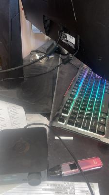 Zbliżenie na tył monitora z podłączonymi kablami, obok leży klawiatura RGB.