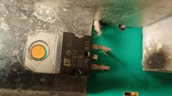 Zbliżenie na triak BTB16-800B przykręcony do radiatora, część modułu elektronicznego pralki.