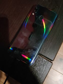 Tył telefonu Samsung A40 w ciemnym otoczeniu na stole.