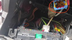 Zdjęcie skrzynki bezpieczników pod kierownicą w Peugeot 307SW z niepodłączoną wtyczką i uciętym brązowym przewodem.