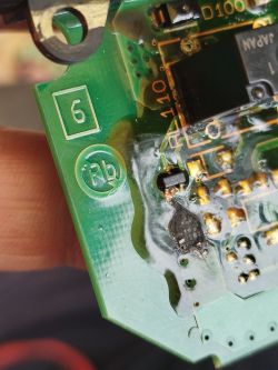 Close-up of a green PCB with SMD parts and a scorched, melted-looking area