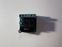 Zdjęcie elektronicznego modułu sterownika z kilkoma złączami i przekaźnikiem.
