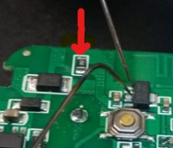 Close-up of a circuit board with various electronic components and a red marker.