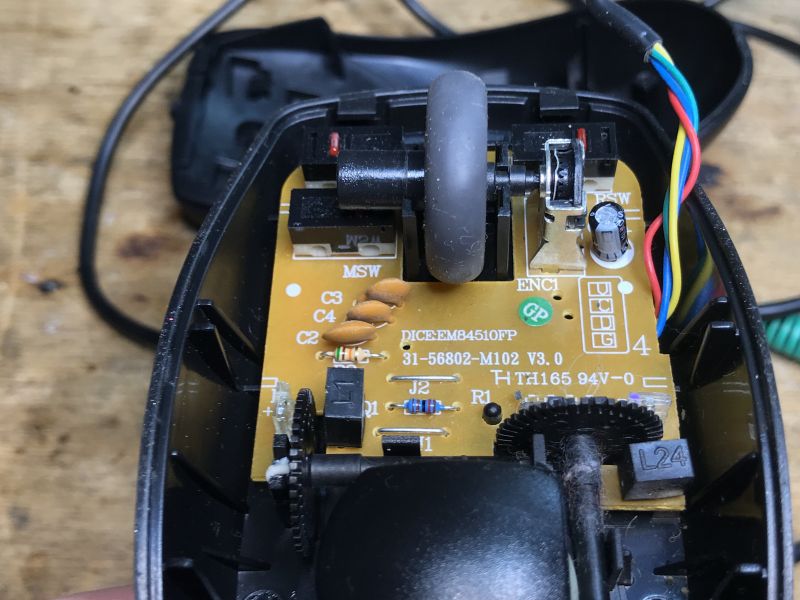 Interior of an Old Computer Mouse with EM84510FP Chip Interior of an old computer mouse with visible circuit board and wheel.