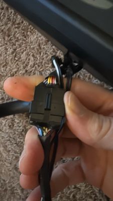 Nahaufnahme eines Kabelverbinders mit bunten Drähten in einer Hand