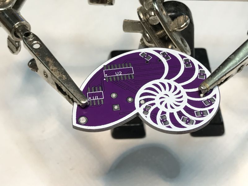 Shell Pattern PCB for SMD Soldering Shell-shaped PCB with SMD mounting markings.