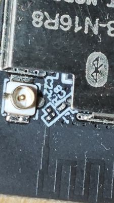 Close-up of an antenna connector on a PCB with visible solder bridge