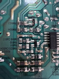 Uszkodzona płytka zasilacza z nadpalonymi elementami w systemie Samsung HT-J5150 Zbliżenie uszkodzonej płytki PCB z nadpalonymi elementami i oznaczeniami komponentów.