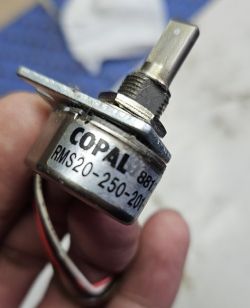 Zbliżenie na enkoder optyczny COPAL RMS20-250-201-1T trzymany w palcach.