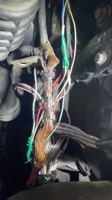 Przegrzane i uszkodzone kable samochodowe z odsłoniętymi miedzianymi przewodami.