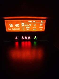 Wyświetlacz Peugeot 207 z zapalonymi kontrolkami airbagów, nie zapiętych pasów i otwartych drzwi.