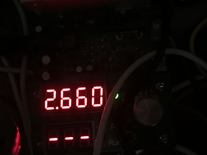 Wyświetlacz LED pokazujący wartość 2.660 w ciemnym otoczeniu, otoczony przewodami.