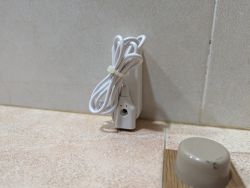 Close-up of a sensor with an attached cable secured with hot glue.