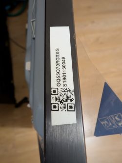 Naklejka z kodem QR na krawędzi urządzenia.