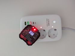 Socket tester plugged into LDNIO power strip showing 239V and one red LED lit