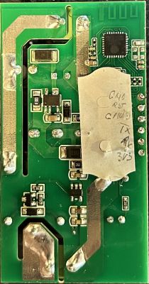 Electronic module with visible pins and a note on paper.