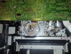 Wnętrze magnetowidu VHS z mechanizmem kasety i płytką drukowaną u góry