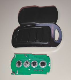 Disassembled remote control with a casing and circuit board with buttons.