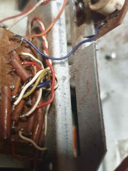 Zbliżenie na wnętrze urządzenia z widocznym okablowaniem i elementami elektronicznymi.