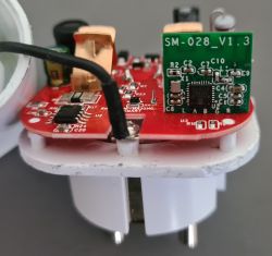 Close-up of the internal electronic components of an eWeLink smart plug on a red PCB with the designation SM-028_V1.3.