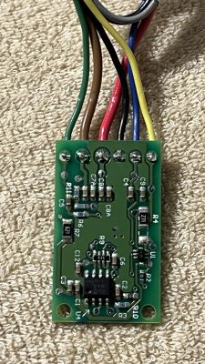 Płytka drukowana z wieloma kolorowymi przewodami przymocowanymi na górze.