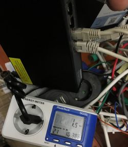 Network switch with Ethernet cables connected and an energy meter showing 1.5 W