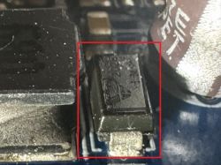 Close-up of a circuit board with a damaged diode marked with a triangle and number 2028 1 M.