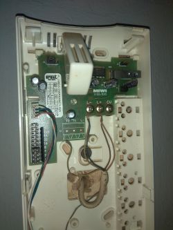 Wnętrze domofonu z widoczną płytką elektroniczną i połączeniami przewodów