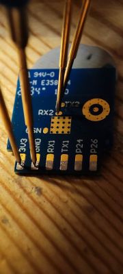 Close-up of a CB2S module with visible pins 3V3, GND, RX1, TX1, P24, P26, and probes connected to the pins.