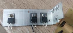 Trzy tranzystory zamontowane na aluminiowym radiatorze.