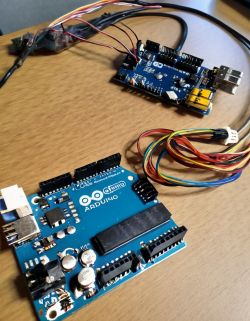 Arduino Microcontrollers with Wires Two Arduino microcontrollers with wires on a wooden table.