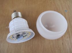 Unscrewed smart LED bulb on a wooden table.