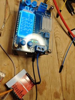 Electronic display and module with wires on a wooden surface.