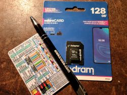 Goodram 128 GB memory card with adapter, pen, and pinout card.