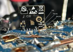 Close-up of an electronic chip attached to a circuit board with connection labels.