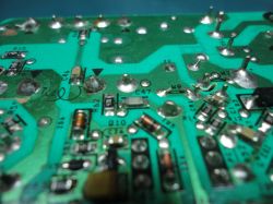 Close-up of a printed circuit board with labeled electronic components, such as capacitors and resistors.