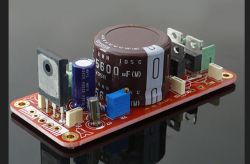 Czerwona płytka drukowana z dużym kondensatorem i kilkoma innymi komponentami elektronicznymi.