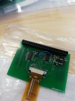 Grüne Leiterplatte mit angebrachtem OLED-Display und elektronischen Bauteilen.