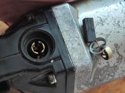 Old Drill with Damaged Switch View of a drill with switch components on a metal casing.